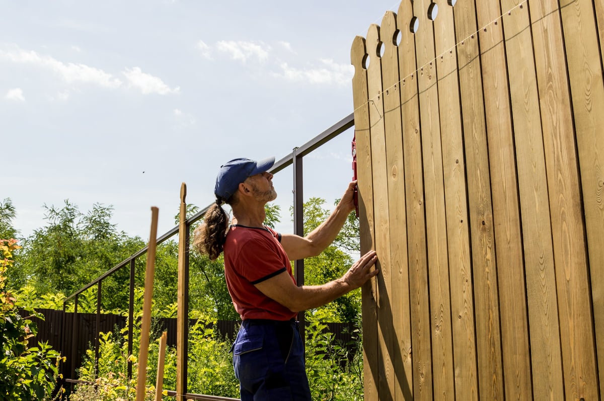 Man building wooden fence